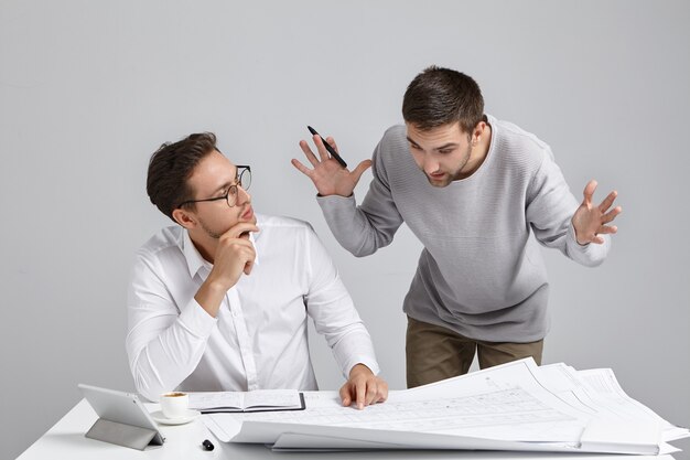Colegas de trabalho do sexo masculino cuidando da papelada