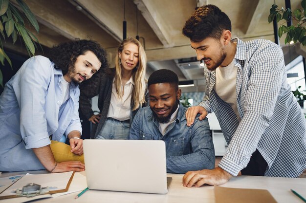 Colegas de trabalho multirraciais sorridentes trabalhando juntos em uma reunião de escritório discutem