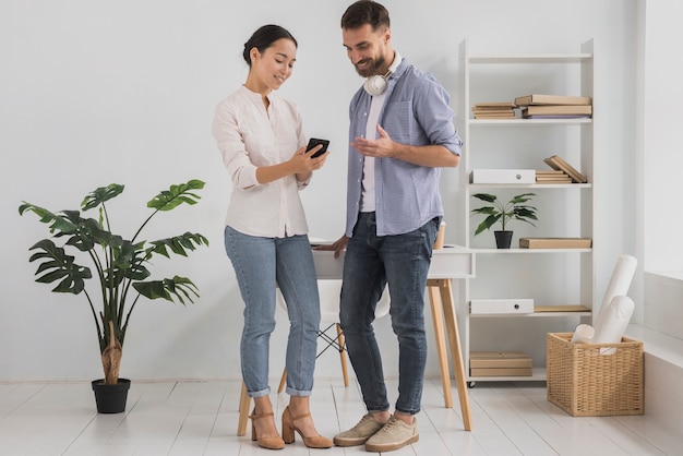 Colegas de trabalho no escritório usando o telefone