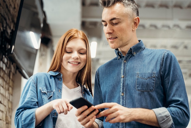 Foto grátis colegas de trabalho olhando ao telefone