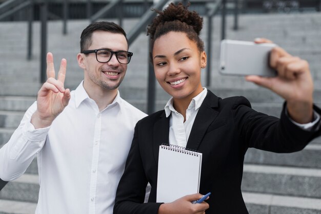 Colegas de trabalho que tomam selfie brincalhão