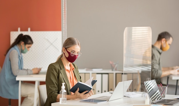 Colegas de trabalho usando máscara no trabalho