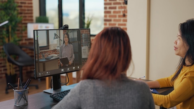 Foto grátis colegas de trabalho usando videochamada remota para entrevista de emprego com candidato no escritório. mulheres de negócios reunidas com candidato em teleconferência online para falar sobre processo de recrutamento e contratação.