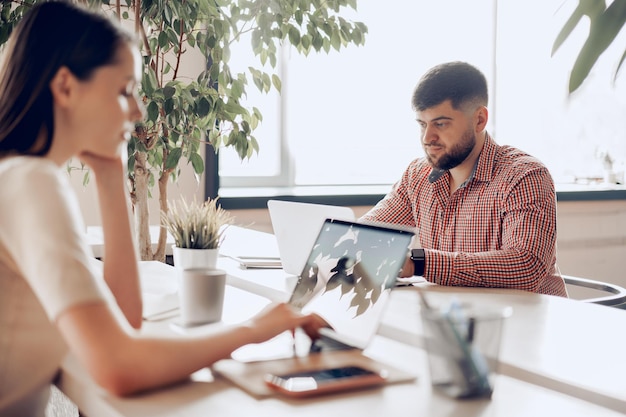 Colegas do sexo masculino e feminino trabalhando à mesa no escritório