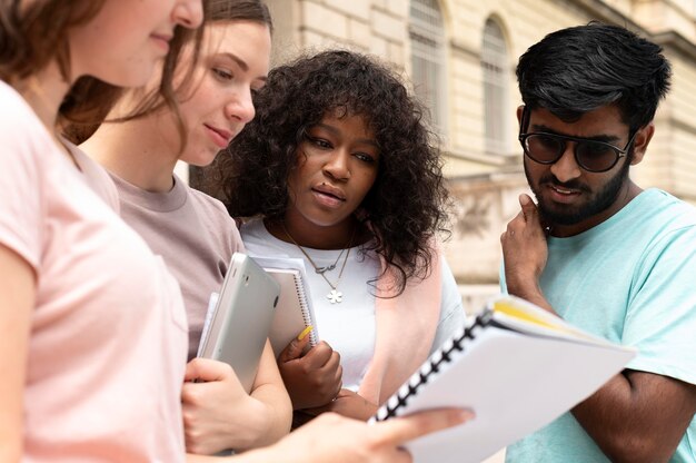 Colegas estudando juntos na frente de sua faculdade