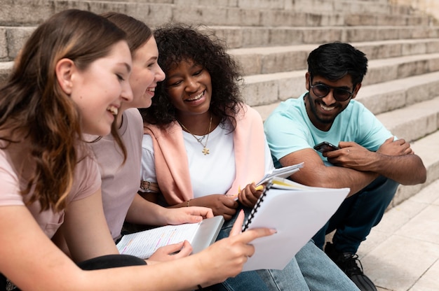 Foto grátis colegas estudando juntos na frente de sua faculdade