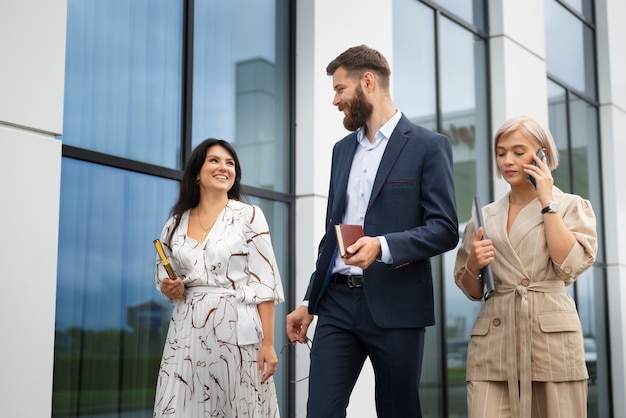 Colegas sorridentes de tiro médio indo trabalhar