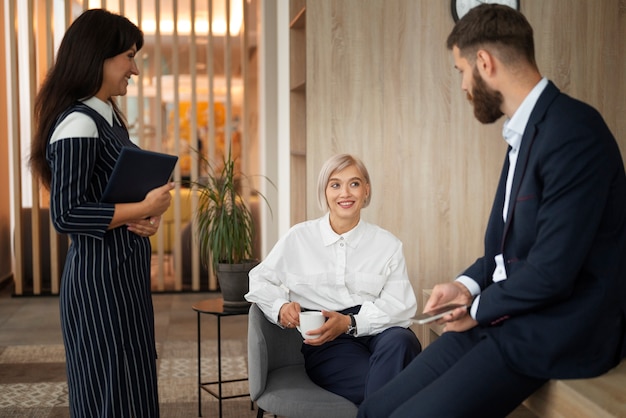 Colegas sorridentes de tiro médio no trabalho