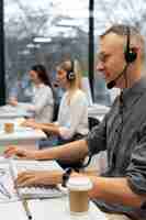 Foto grátis colegas trabalhando juntos em um escritório de call center com café