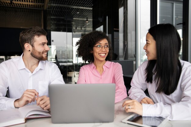 Colegas trabalhando juntos em um laptop e conversando