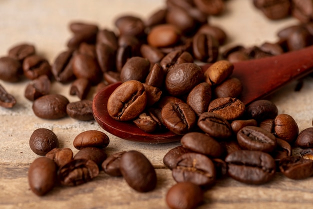 Colher de close-up com grãos de café torrados
