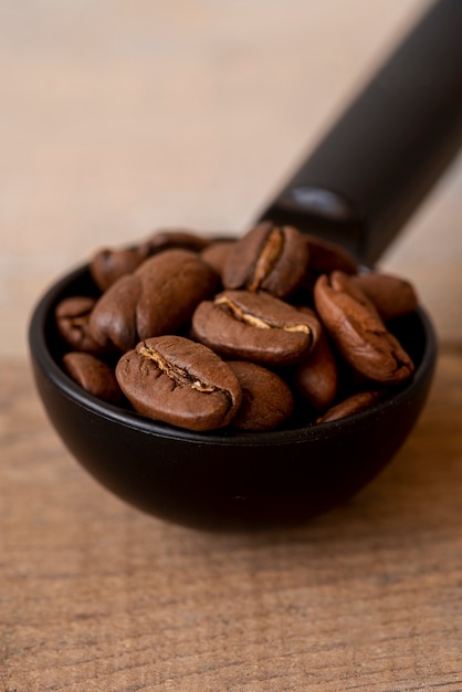 Foto grátis colher de close-up com grãos de café torrados