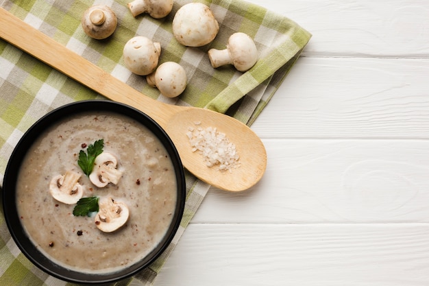 Colher plana de madeira e bisque de cogumelos com cogumelos