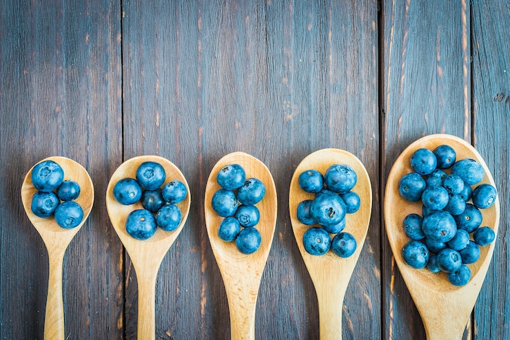 Foto grátis colheres de madeira com blueberries