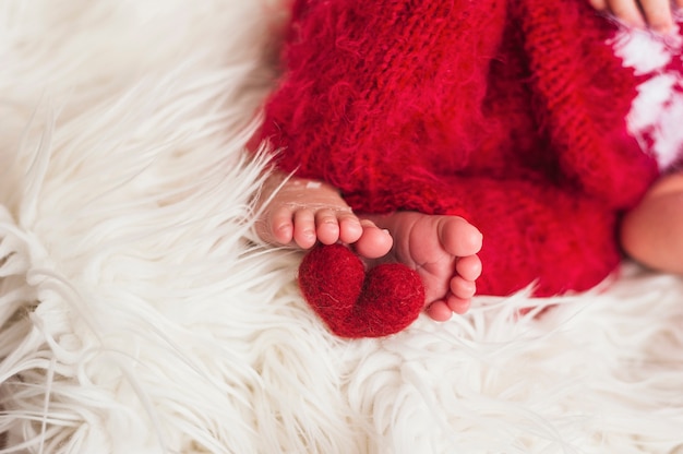 Coloque os pés do bebê com coração vermelho perto
