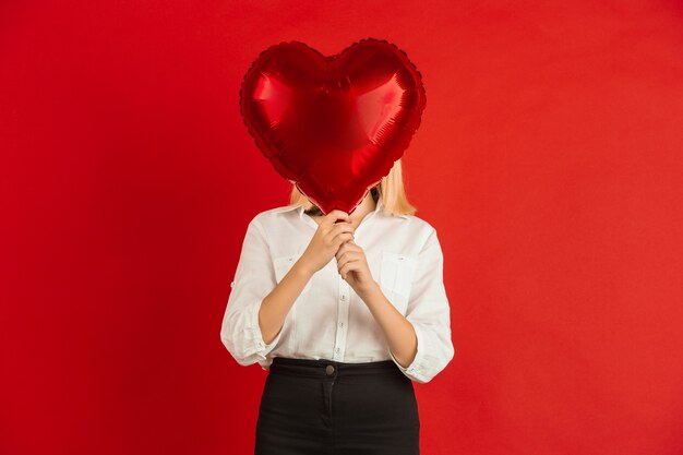 Comemoração do dia dos namorados, felizes, lindos garotos caucasianos isolados no estúdio vermelho