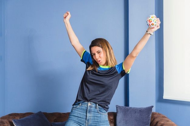 Comemorando o fã de futebol feminino no sofá