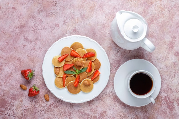 Comida da moda - cereal mini panqueca. pilha de panquecas de cereais com frutas e nozes.