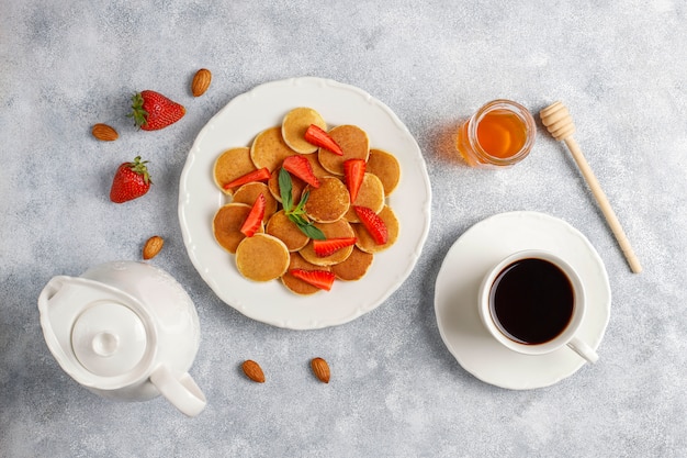 Comida da moda - cereal mini panqueca. Pilha de panquecas de cereais com frutas