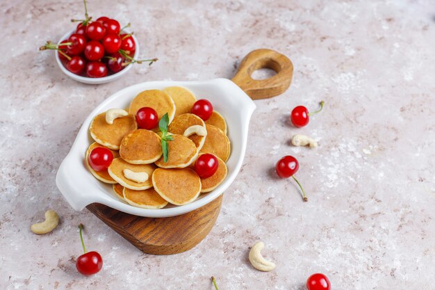 Comida da moda - cereal mini panqueca. Pilha de panquecas de cereais com frutas