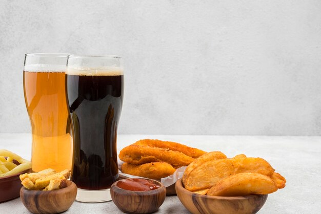 Comida deliciosa e arranjo de copos de cerveja