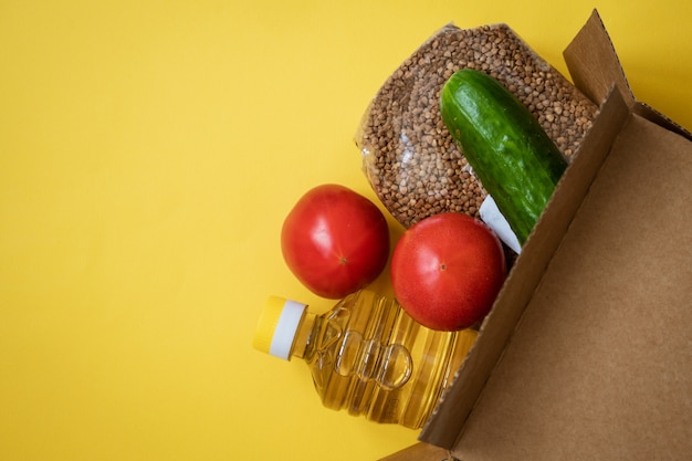 Comida em uma caixa de papelão em um fundo amarelo