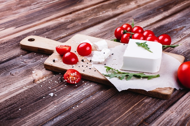 Comida fresca e saudável. delicioso jantar italiano. queijo fresco servido na tábua de madeira