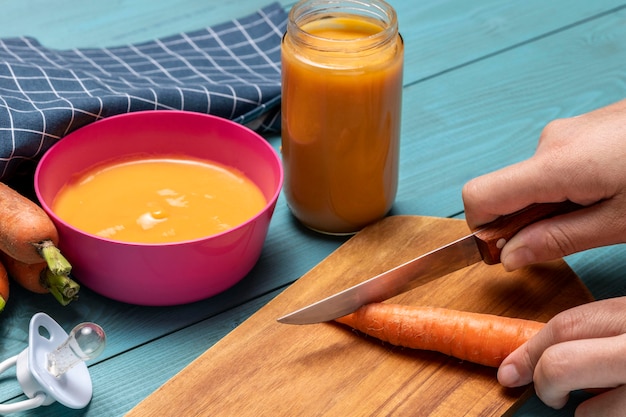 Comida para bebê de ângulo alto com cenoura e chupeta