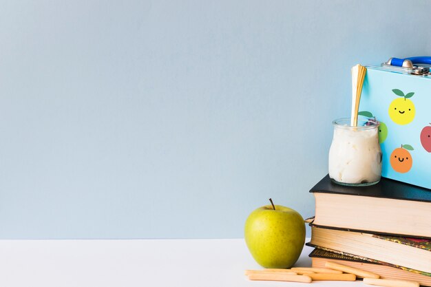 Comida saudável perto de livros e lancheira