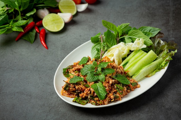 Comida tailandesa; carne picada de porco picante servida com acompanhamentos