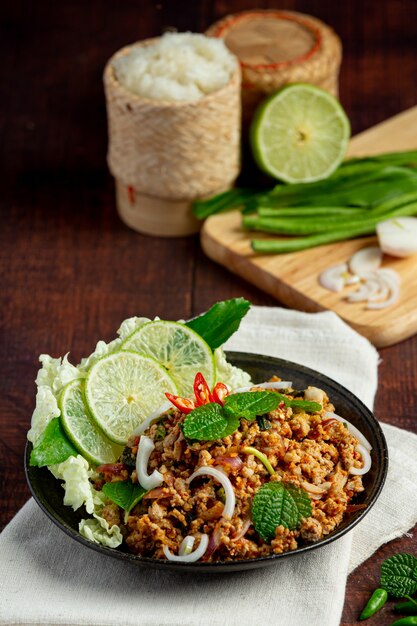 Comida tailandesa com carne de porco picada picante e acompanhamentos