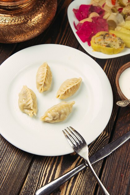 Comida tradicional caucasiana, khinkali, dushbere, gurze servido com turshu.