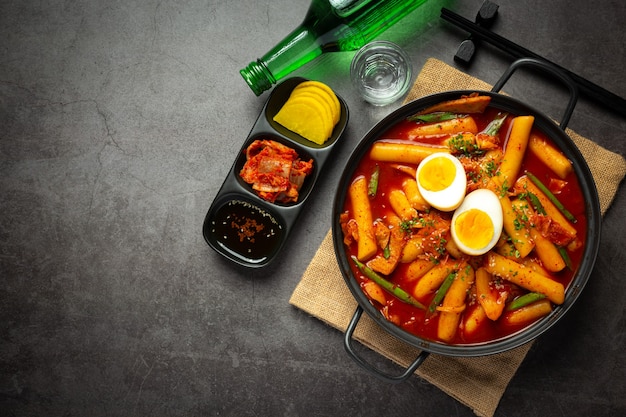 Comida tradicional coreana de queijo tokbokki no fundo do quadro negro. prato de almoço.