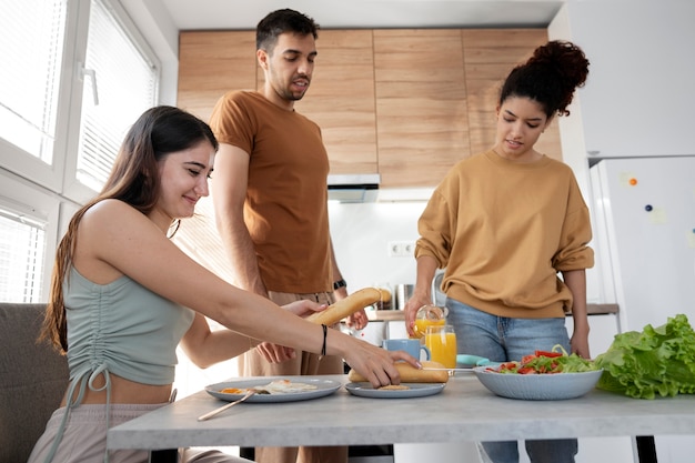 Foto grátis companheiros de quarto tiro médio com comida