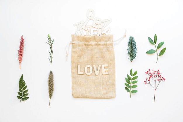 Composição com folhas e letras de amor no saco