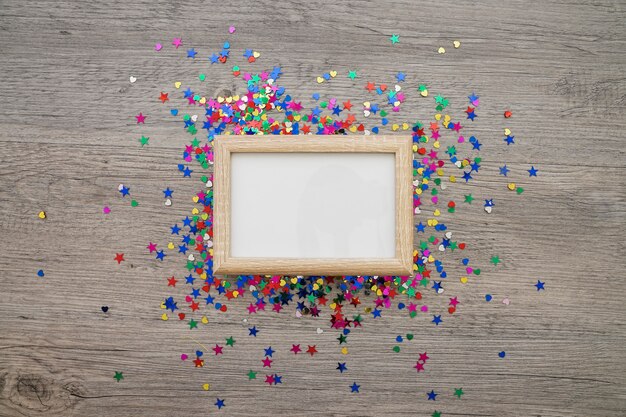 Composição com quadro em branco e confetes coloridos