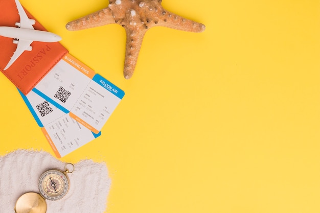 Composição de bilhetes de passaporte pequeno avião estrela e bússola na toalha