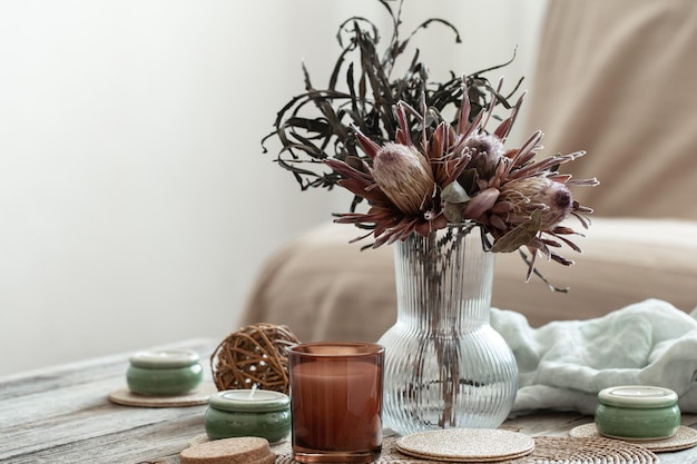 Composição de casa aconchegante com velas e buquê de protea