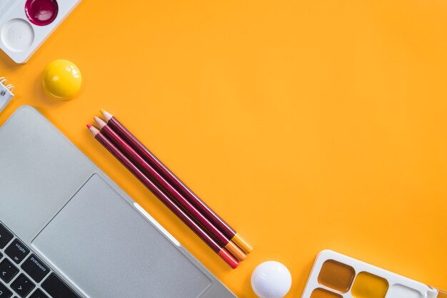 Composição de ferramentas de laptop e papelaria para pintura