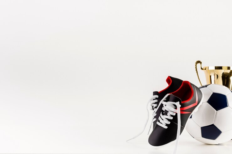 Foto grátis composição de futebol com sapatos e bola ao lado de copyspace