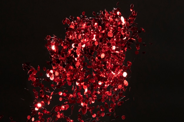 Composição de glitter vermelho em fundo preto