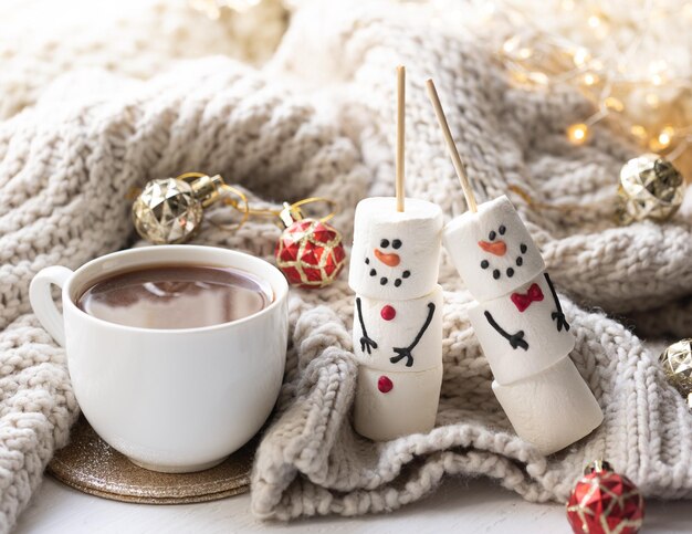 Foto grátis composição de inverno com uma xícara de cacau e marshmallows em um fundo desfocado