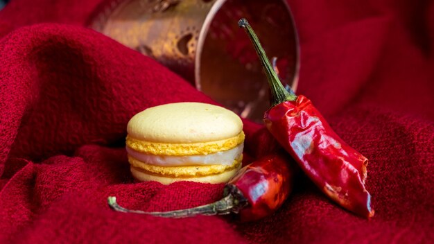 Composição de macaron amarelo Pimentas e macaron em um tecido vermelho