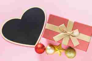 Foto grátis composição de natal da caixa de presente rosa com lousa