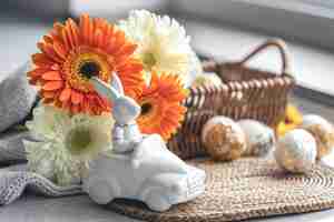 Foto grátis composição de páscoa com flores e ovos de gerbera de lebre de cerâmica