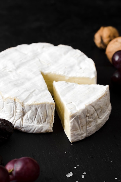 Foto grátis composição de queijo de alto ângulo em fundo preto