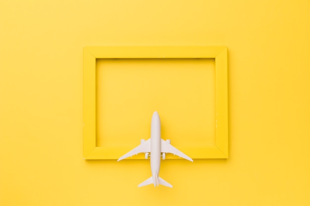 Composição do avião de brinquedo no quadro amarelo