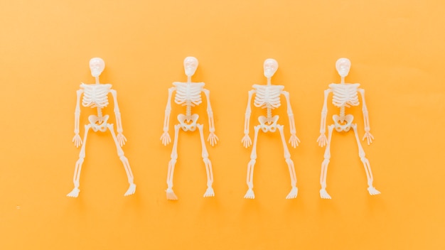 Foto grátis composição do dia das bruxas com quatro esqueletos