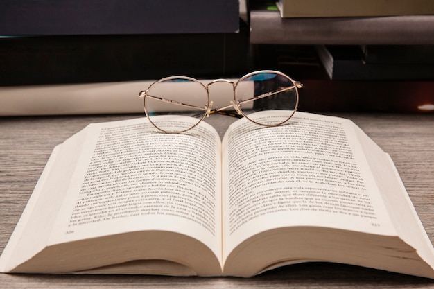 Composição do livro com óculos de leitura no livro