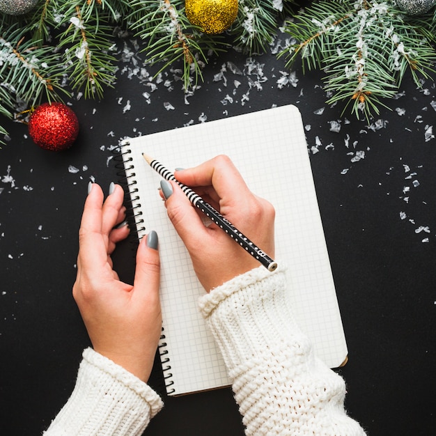 Composição do Natal com as mãos escrevendo